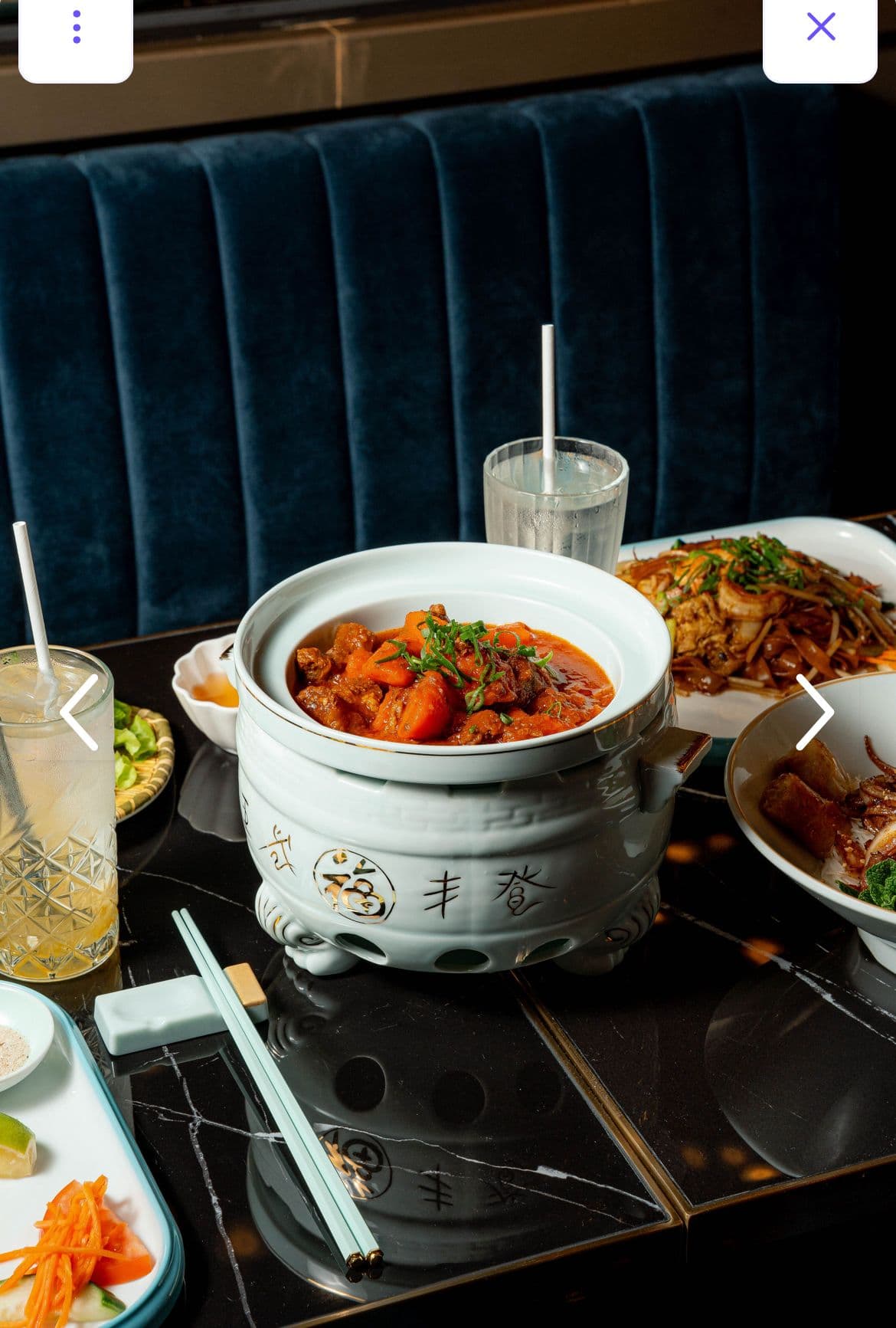 Marmite sur table de marbre noir, banquette velours en arrière-plan